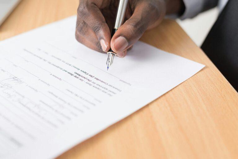 Photo d'un notaire en train de signer un document